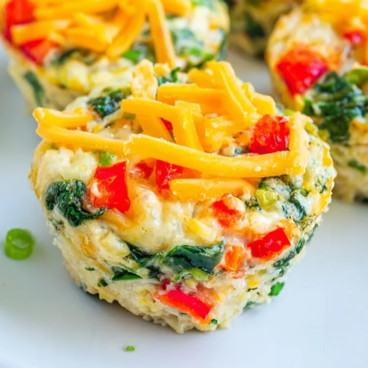 Golden baked egg muffins with spinach and cheddar, ready for a quick breakfast bite.