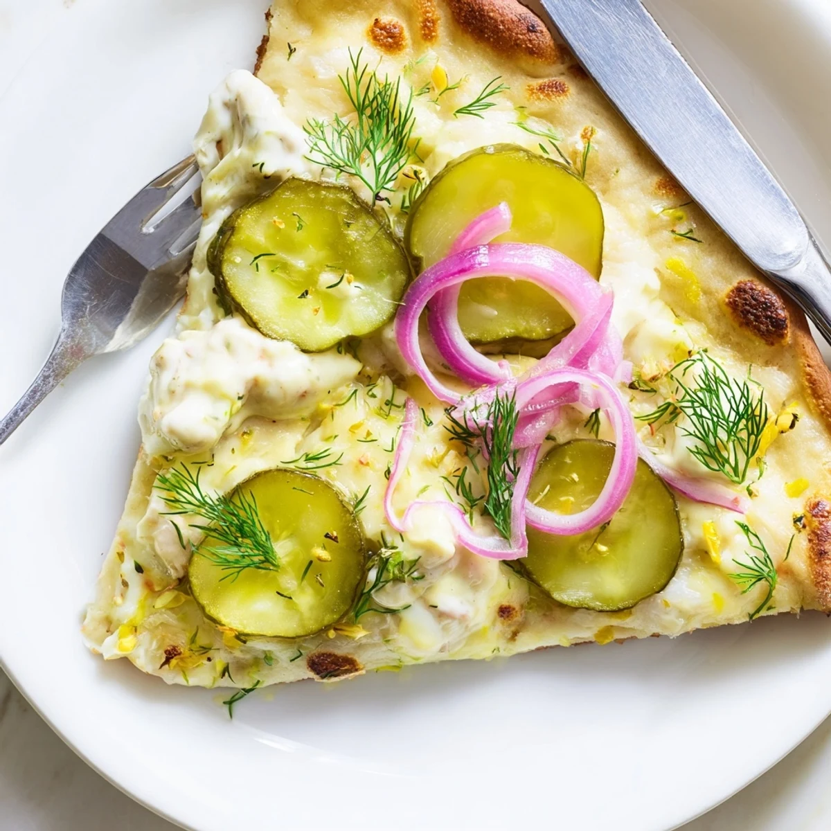 Creamy Pickle Pizza topped with mozzarella, dill, and tangy crème fraîche sauce.  
