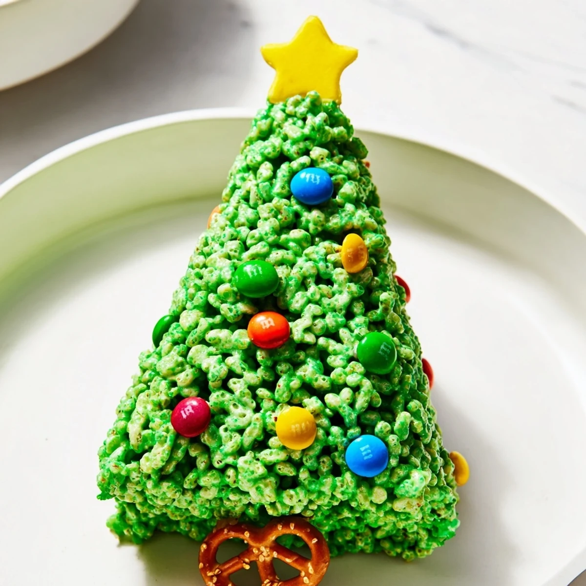 Sweet, crunchy Christmas Tree Rice Crispy Treats, coated in green marshmallow and sprinkled with festive candies.