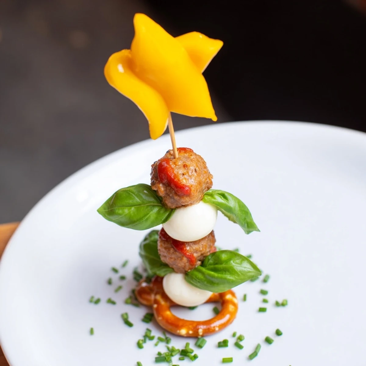 Golden-brown Mini Meatball Christmas Trees stacked with mozzarella and basil for a holiday appetizer.