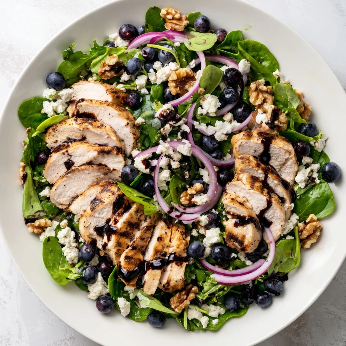 A close-up view of the finished Blueberry Goat Cheese Chicken Salad with balsamic drizzle.