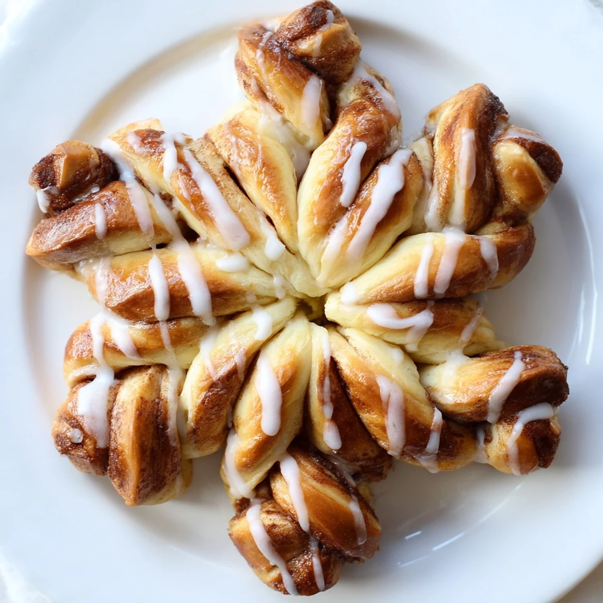 Fluffy Cinnamon Roll Pull-Apart Snowflake with golden edges and a sweet vanilla icing drizzle.