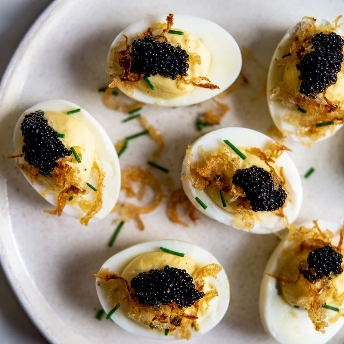 Beautiful close-up of deviled eggs with caviar and golden shallots; flavorful, elegant party food.