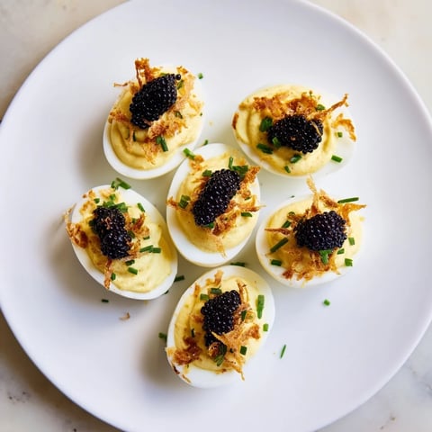 Sumptuous deviled eggs with caviar and crispy shallots, a gourmet appetizer idea for a party.