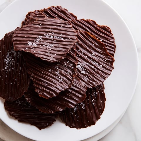 Melted chocolate drizzled over potato chips, making delicious chocolate potato chip bark ready to eat.