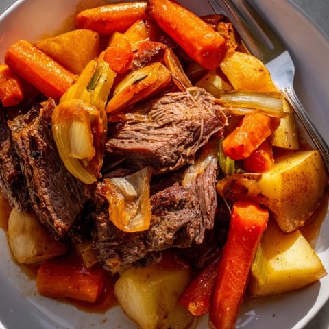 Tender Sunday Pot Roast glistening with savory juices alongside colorful roasted vegetables.  
