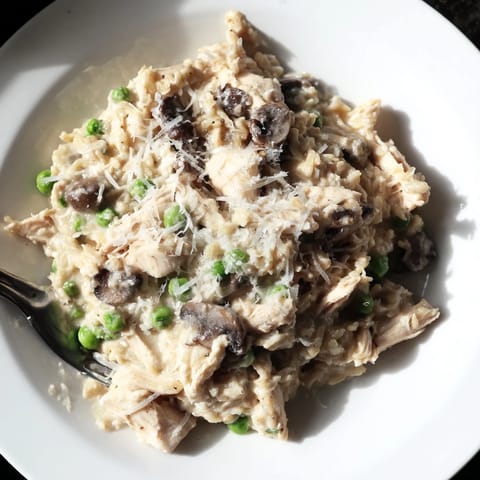 Slow-cooked Creamy Chicken Alfredo, a steaming bowl of pasta covered in rich, savory sauce.