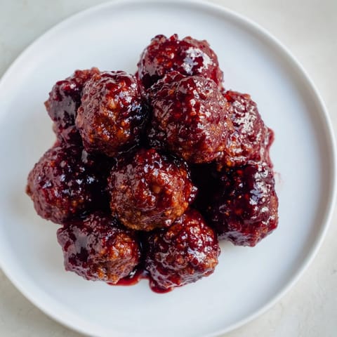 Sweet and savory cherry-glazed meatballs, ready to be served, offering a burst of flavor in every bite.