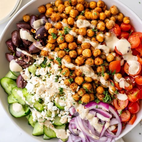 A flavorful closeup shows a delicious Mediterranean Chickpea Bowl served with lemon wedges and feta.