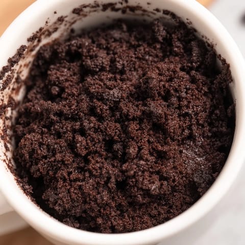 Rich, dark Oreo Mug Cake, freshly made, offers a quick and easy dessert experience.