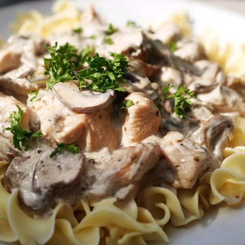 Warm, luscious Chicken and Mushroom Stroganoff with tender chicken pieces and earthy mushrooms, finished with fresh parsley and ready to enjoy over fluffy egg noodles.