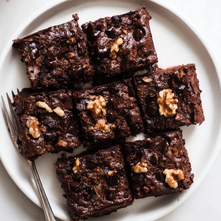 Indulgent Zero-Waste Brownies topped with nuts and served warm with ice cream.  