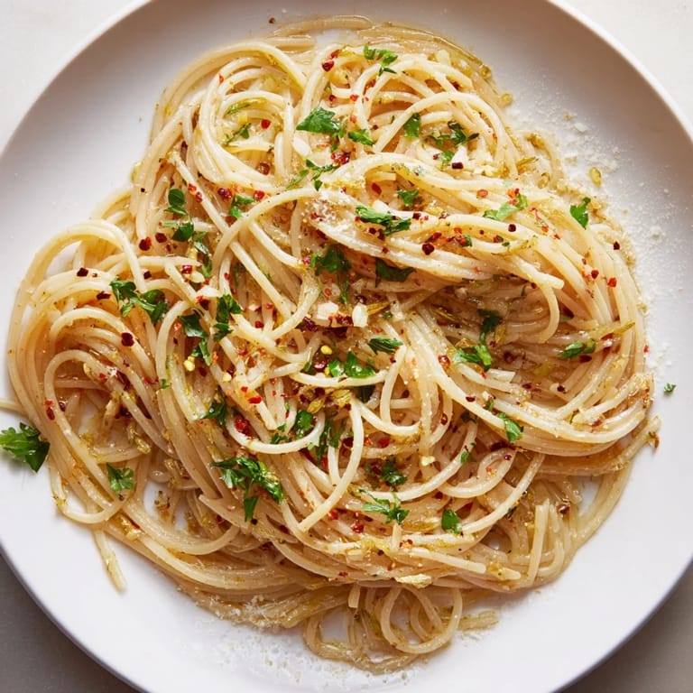 Close-up of Aglio e Olio Express Pasta; fragrant, tossed spaghetti with parsley, ready to eat.
