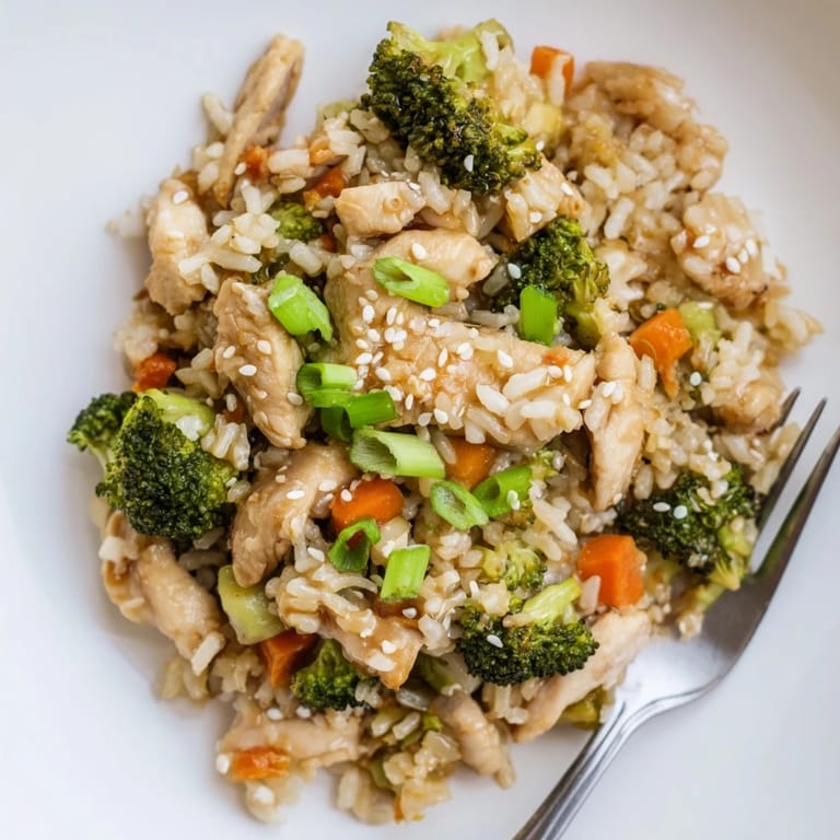 Ready to serve, this One Pan Honey Garlic Chicken Broccoli Rice is garnished with sesame seeds and fresh green onions.