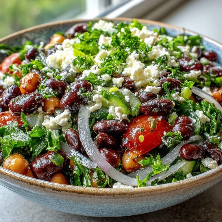 A chilled bowl of Divorce Salad featuring marinated beans, tangy feta, and thinly sliced red onion for crunch.
