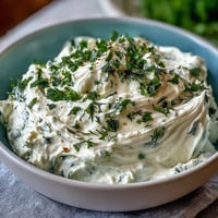 Creamy whipped cottage cheese ranch dip with fresh herbs and crunchy veggie sticks for a healthy snack.